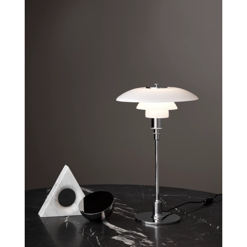 The chrome PH 2/1 Table Lamp from Louis Poulsen in a lounge lifestyle photograph.