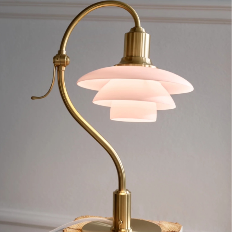 The PH 2/2 Question Mark Pale Rose Table Lamp from Louis Poulsen in a home office.
