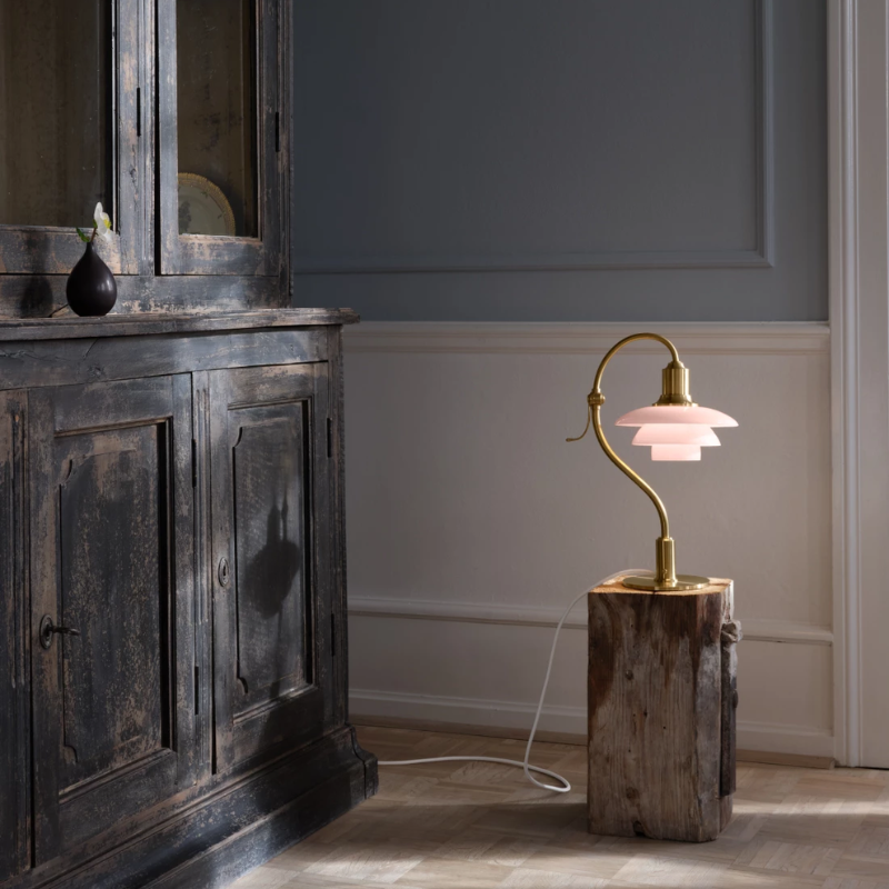 The PH 2/2 Question Mark Pale Rose Table Lamp from Louis Poulsen in a lounge lifestyle photograph.
