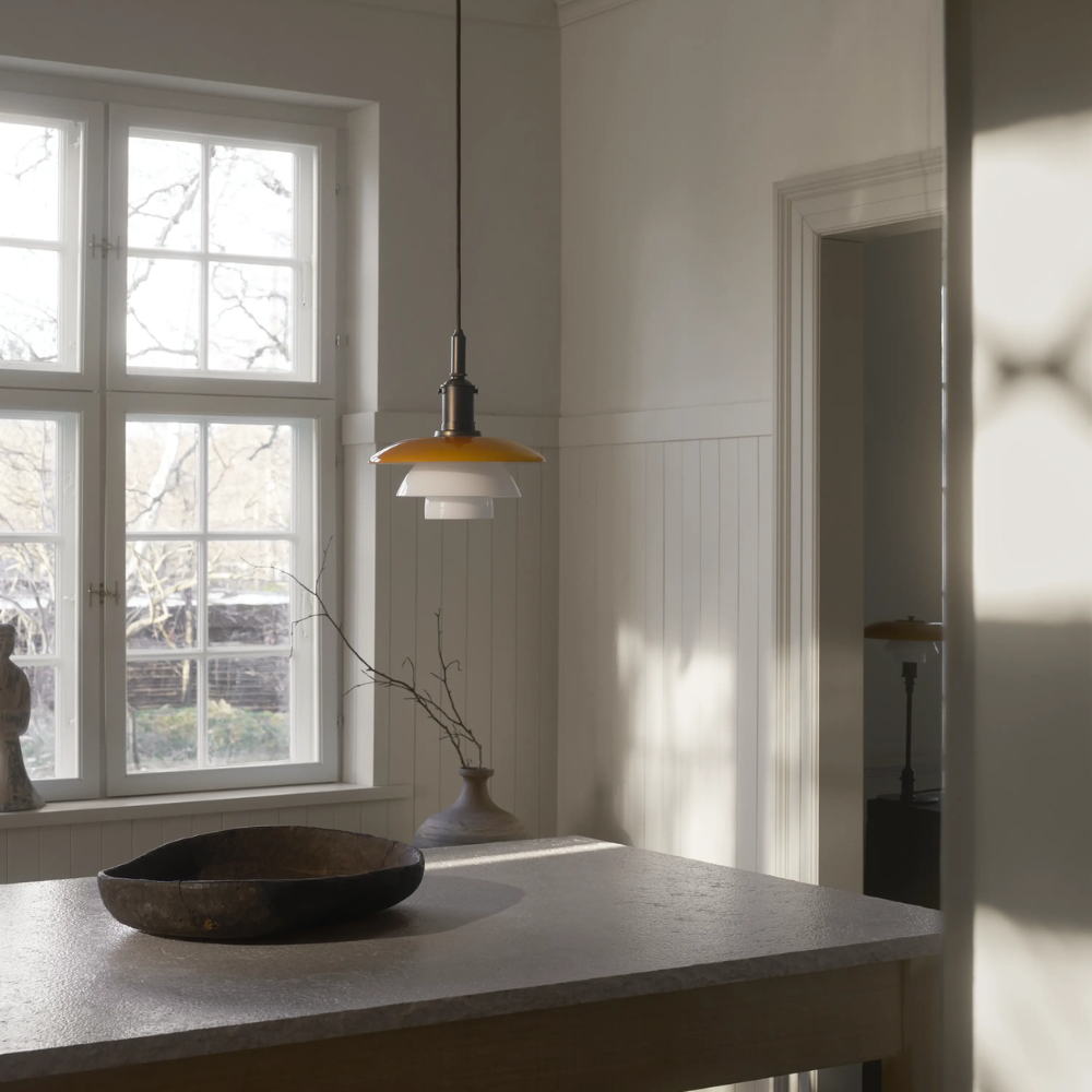 The PH 3/3 Pendant Centenary Edition by Louis Poulsen over a dining room table, turned off.