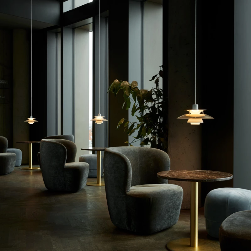 The PH 5 Mini Pendant from Louis Poulsen in brass in a commercial space.