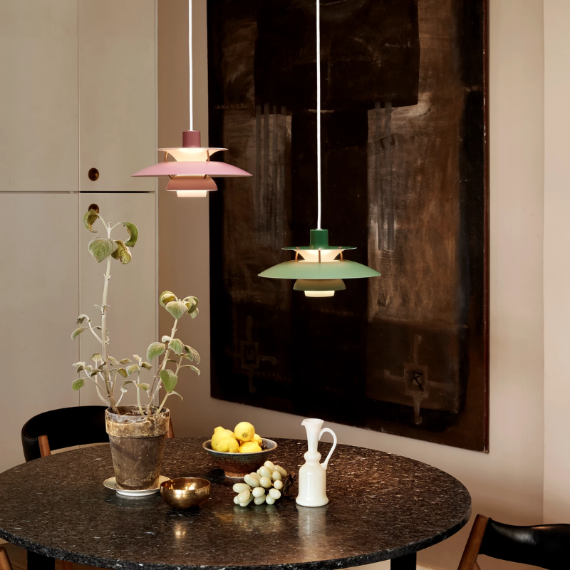 The PH 5 Mini Pendant from Louis Poulsen in hues of rose in a dining area.