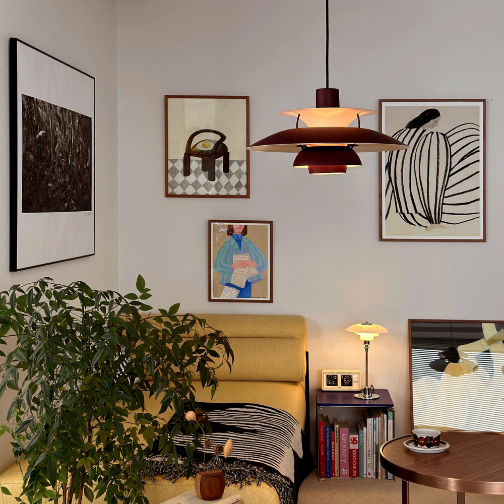 The PH 5 from Louis Poulsen in monochrome burgundy in a living room.