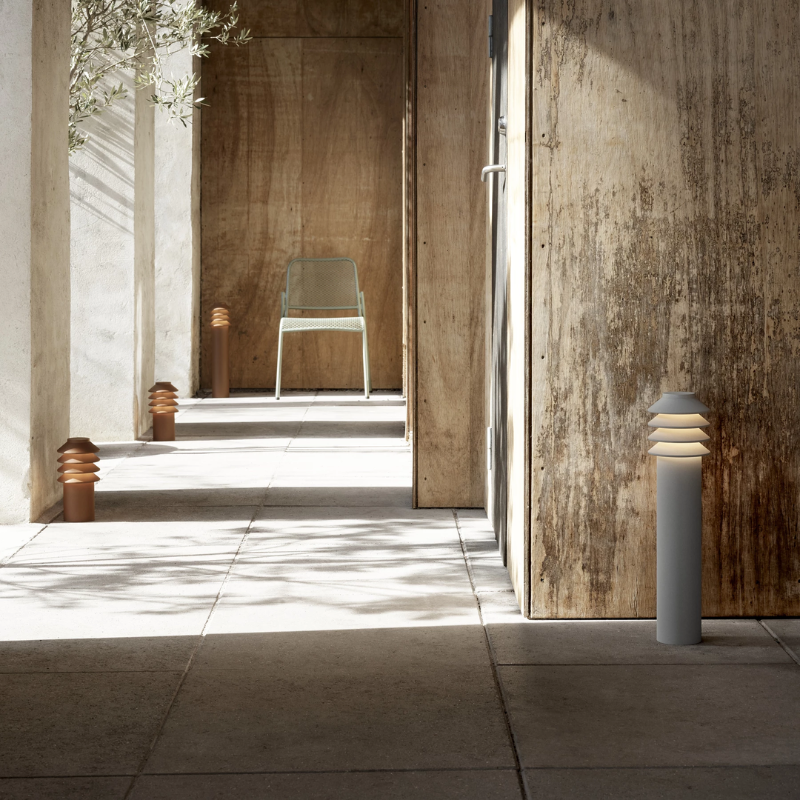 The Short Bysted Garden Bollard from Louis Poulsen in corten in a walkway.