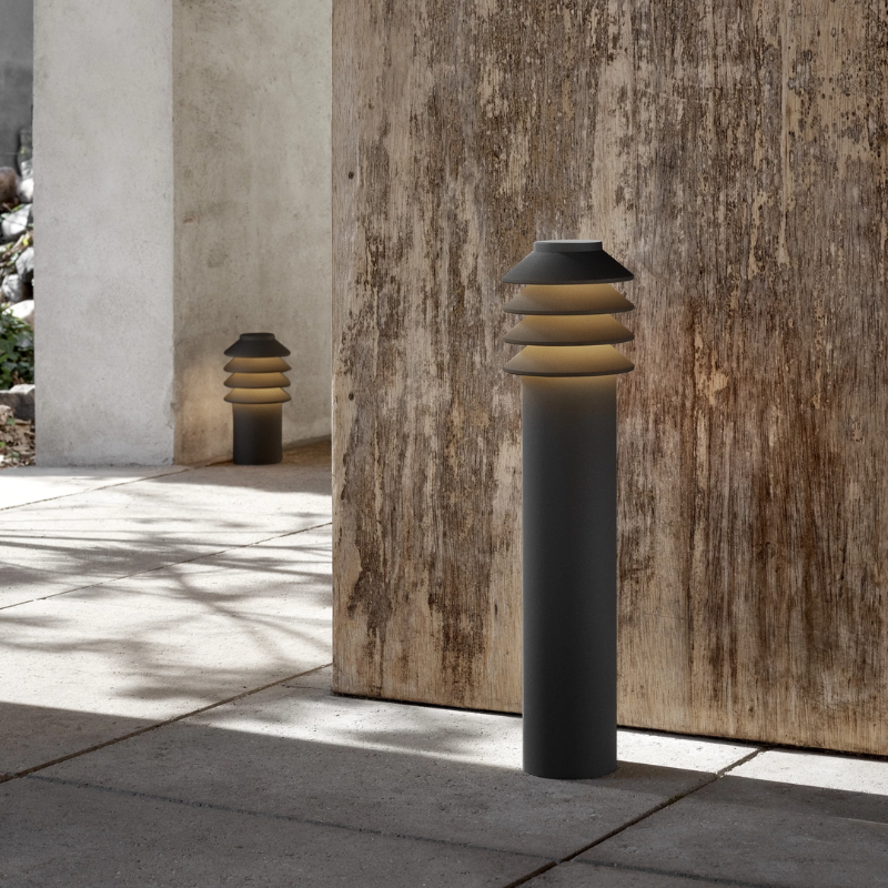 The Tall Bysted Garden Bollard from Louis Poulsen in black in an outdoor living space.