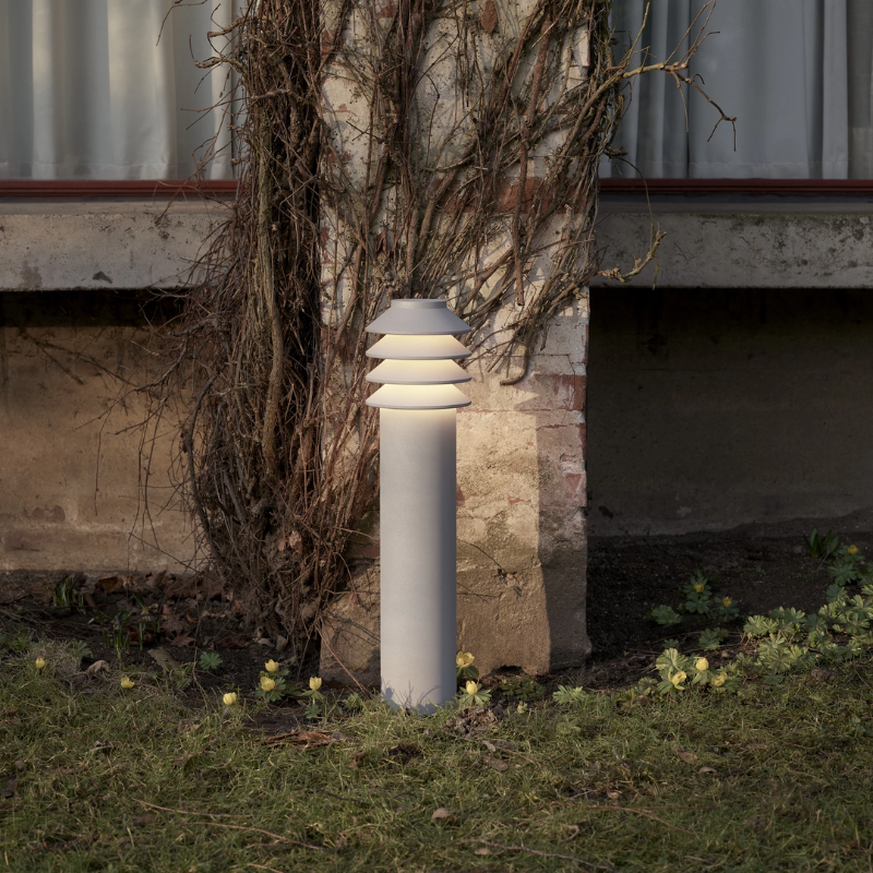The Tall Bysted Garden Bollard from Louis Poulsen in natural paint aluminum outdoors.