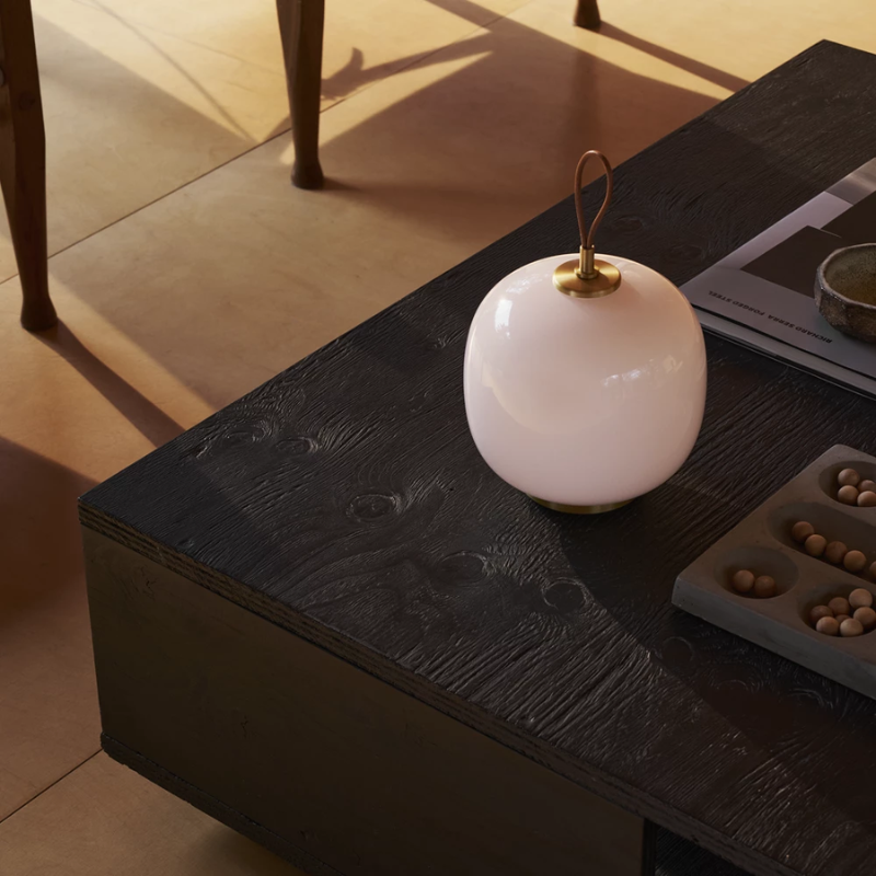 The VL 45 Radiohus Portable Lamp from Louis Poulsen in pale rose glass in a primary bedroom.