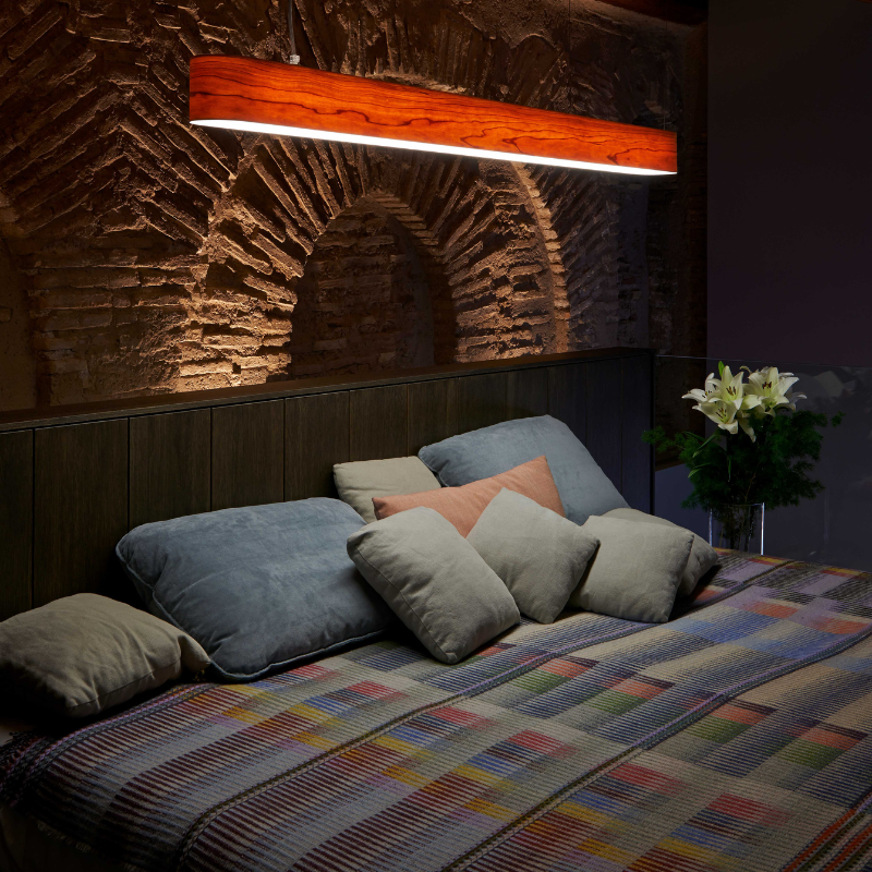 The I-Club Slim Suspension from LZF lamps with the natural cherry veneer in a bedroom.