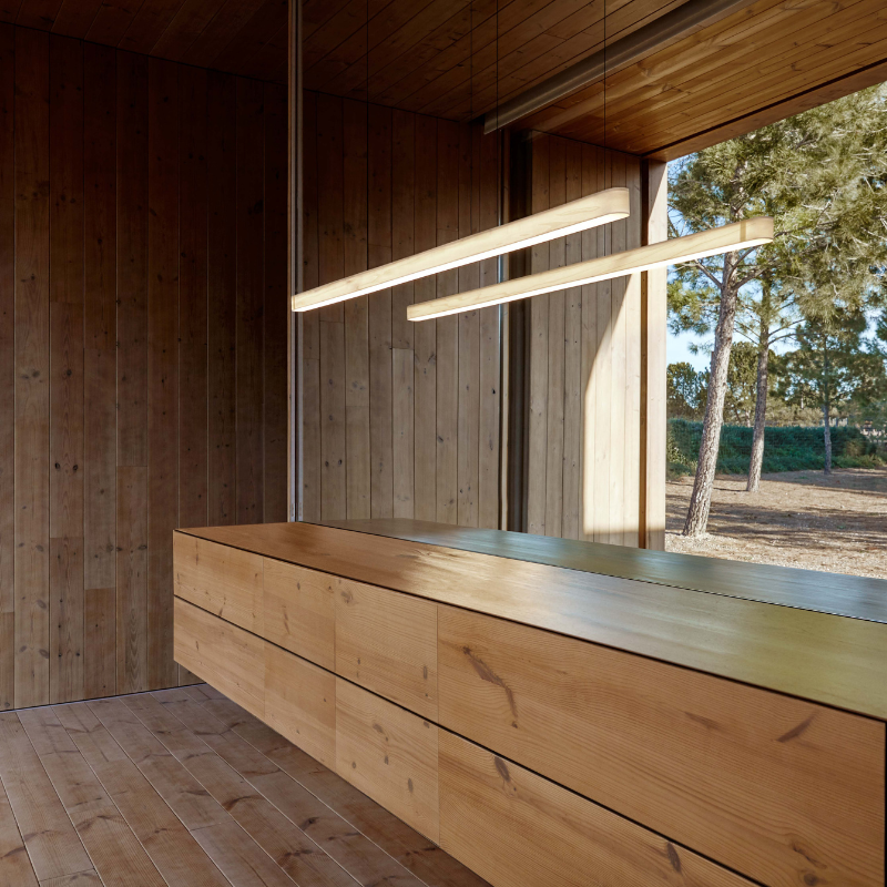 The Long I-Line Suspension from LZF lamps with the ivory white veneer in a family room.