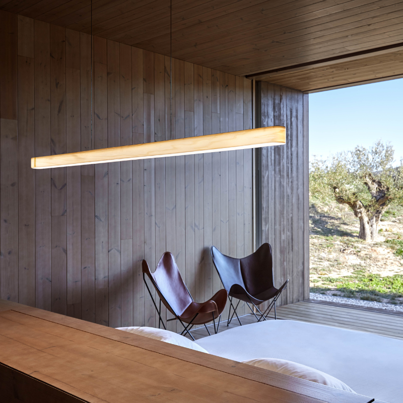 The Long I-Line Suspension from LZF lamps with the ivory white veneer in a living room.