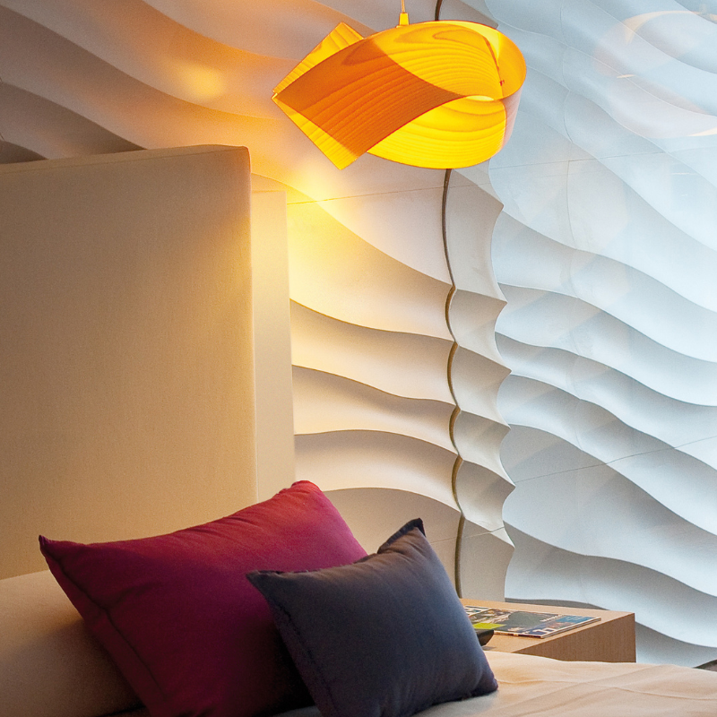 The Nut Suspension from LZF Lamps in yellow in a primary bedroom.