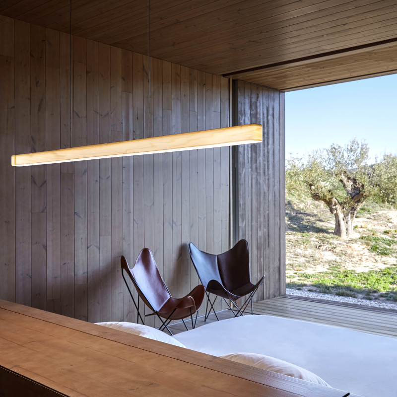 The Short I-Line Suspension from LZF lamps with ivory white veneer in a primary bedroom.