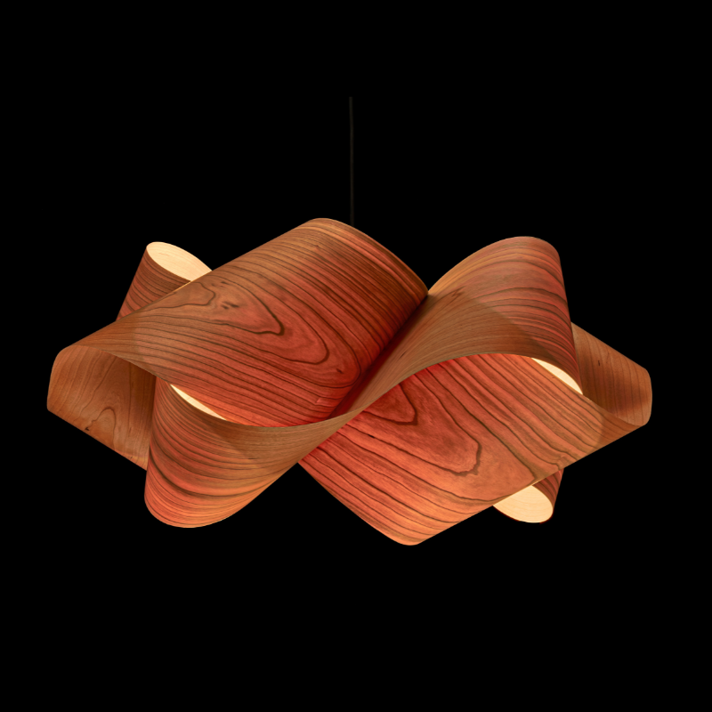 The Swirl Suspension from LZF Lamps in natural cherry in a studio.
