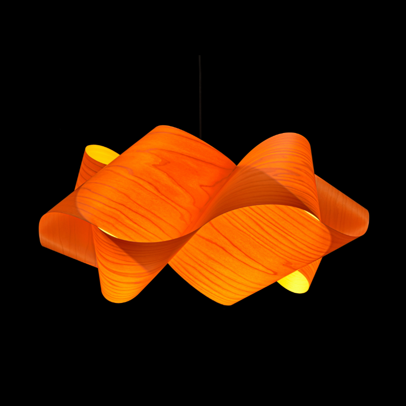 The Swirl Suspension from LZF Lamps in orange in a studio.