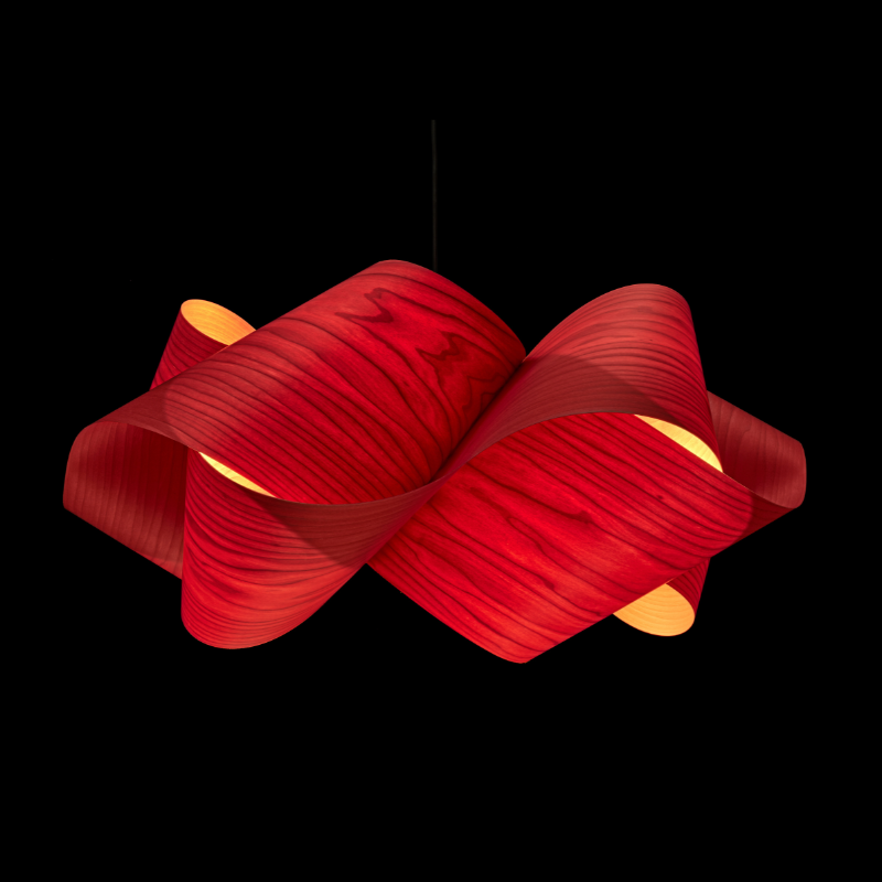 The Swirl Suspension from LZF Lamps in red in a studio.
