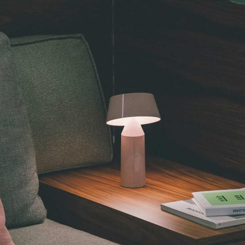The Bicoca Portable Table Lamp from Marset in pale pink in a lounge.