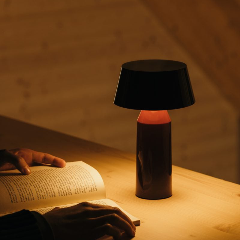 The Bicoca Portable Table Lamp from Marset in red wine in a family area.