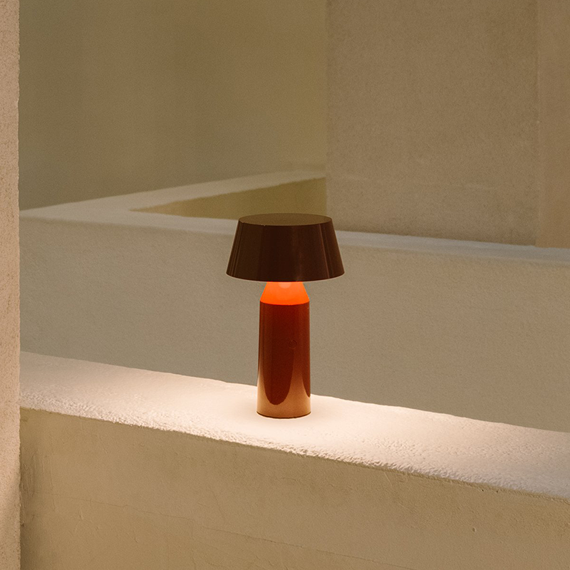 The Bicoca Portable Table Lamp from Marset in red wine in a primary bedroom.