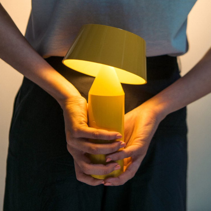 The Bicoca Portable Table Lamp from Marset in yellow in a dining room.