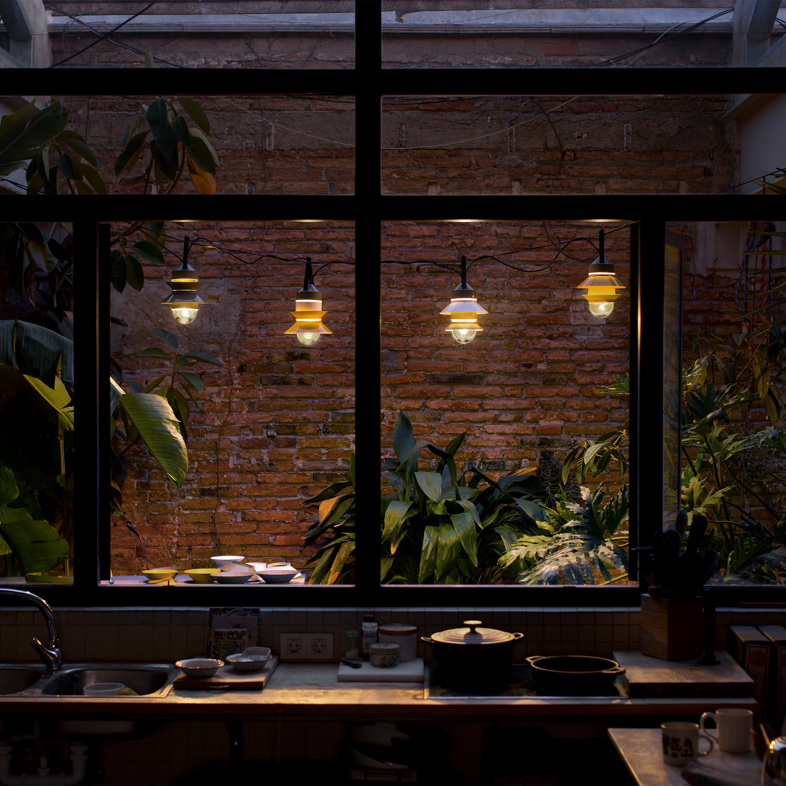 All colors of the Santorini Outdoor Pendant from Marset in a garden. all-groups