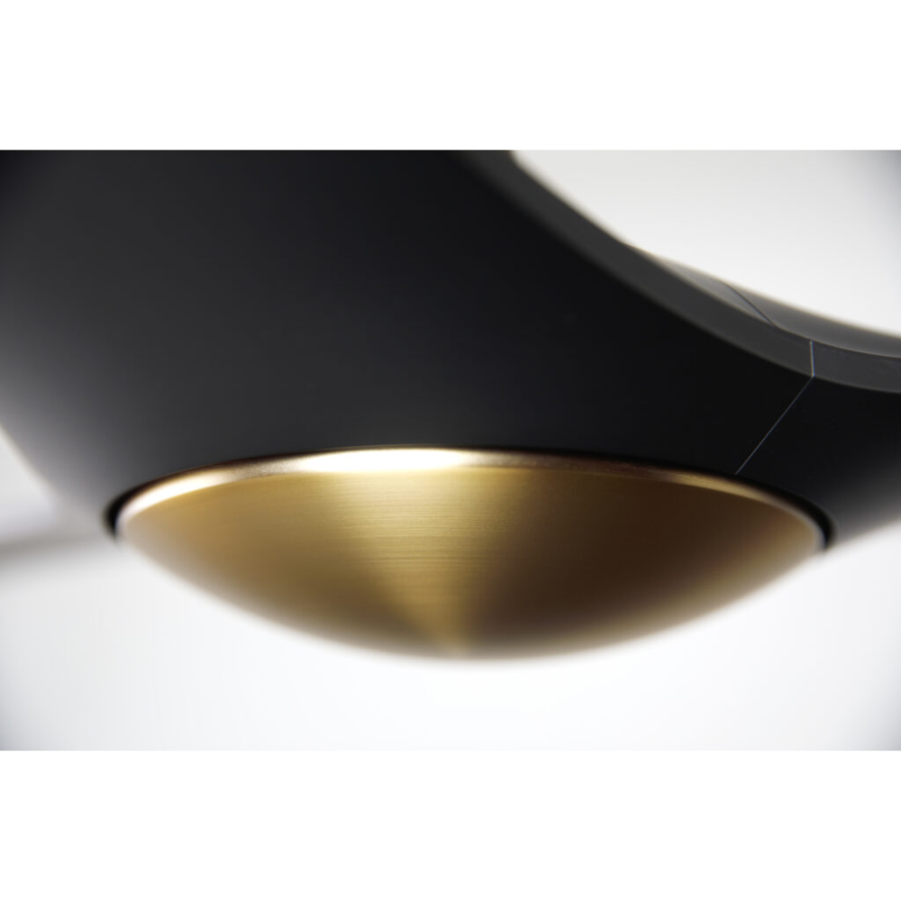 The satin brass and matte black IC/Brisa DC - 56″ from Modern Fan Co. close up in a living space.