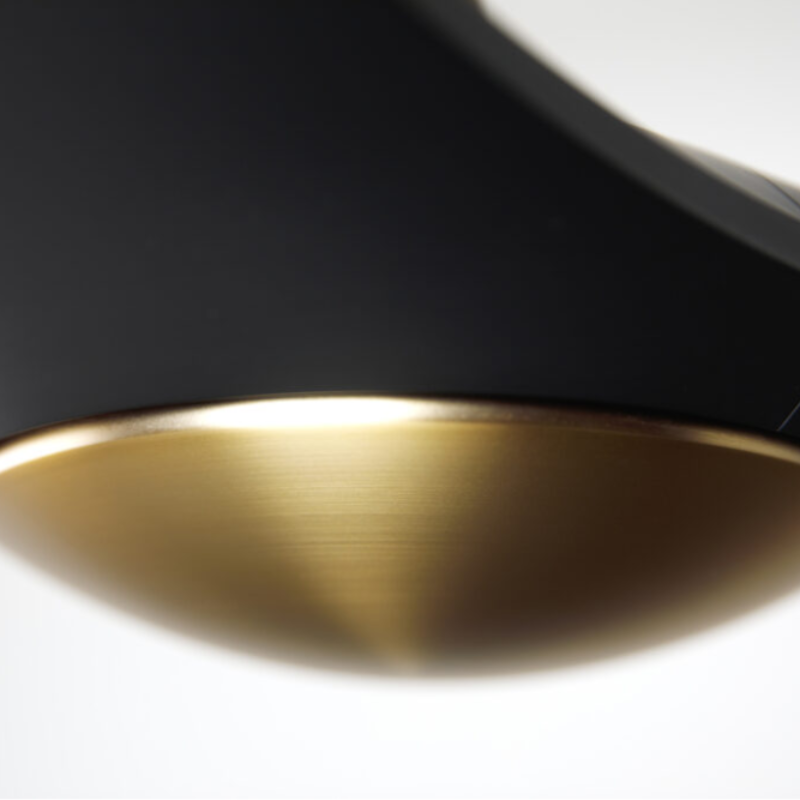 The satin brass and matte black IC/Brisa DC - 56″ from Modern Fan Co. close up in a living space.