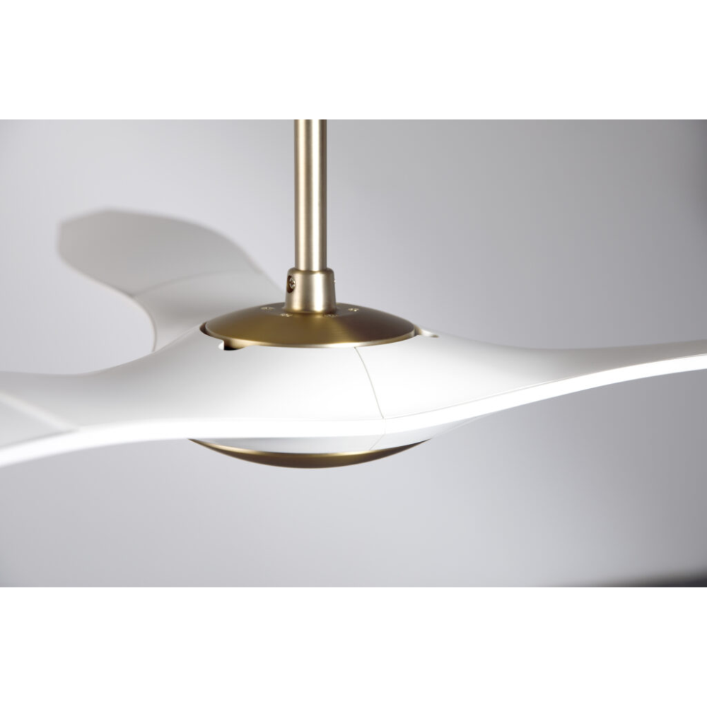 The satin brass and matte white IC/Brisa DC - 56″ from Modern Fan Co. shown from the side in a family area.
