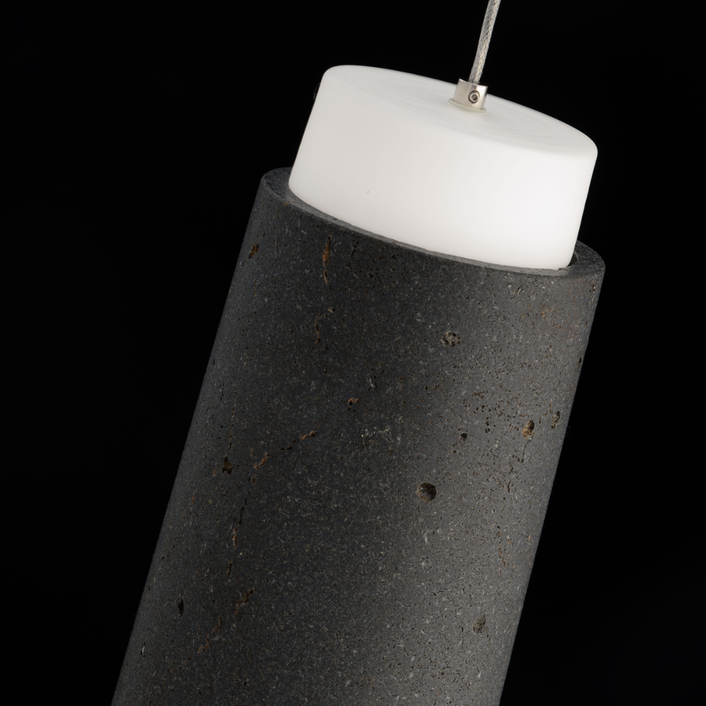 The basalt stone and black Chauncey Pendant Light from Modern Forms in a bedroom.