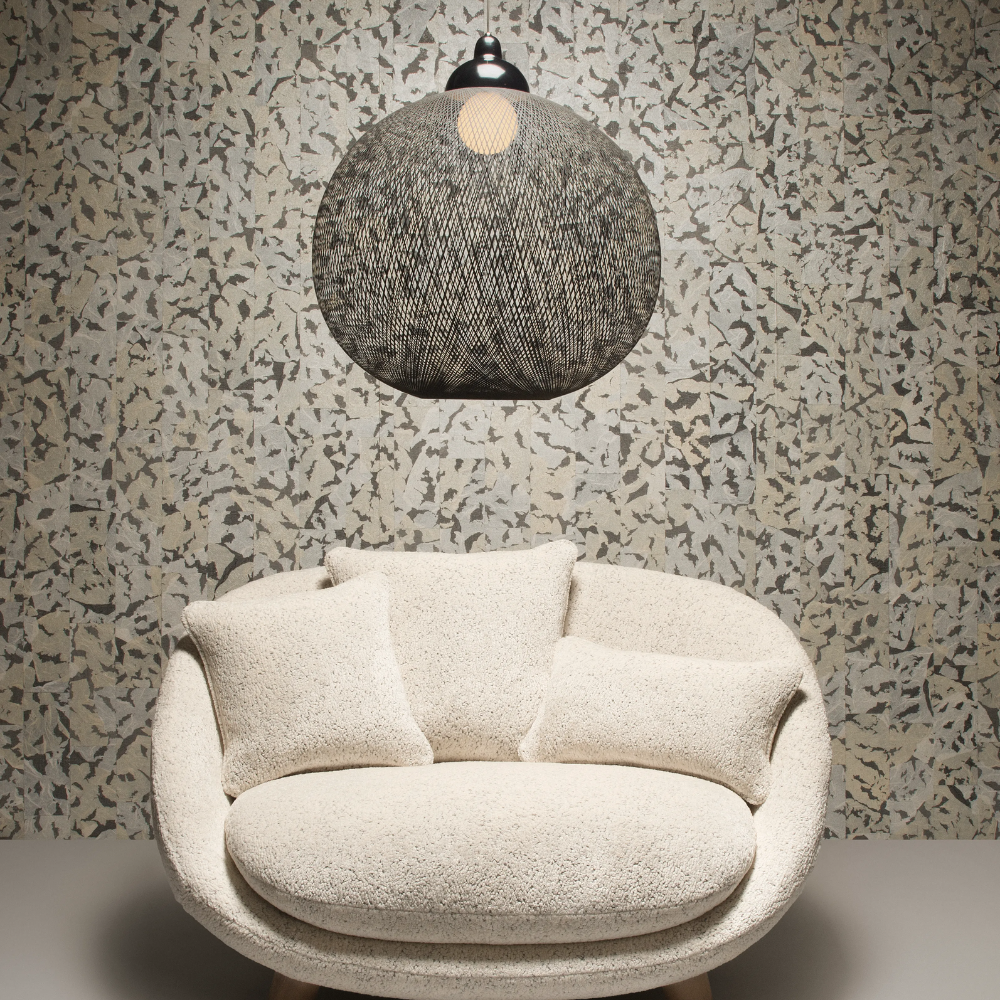 The Non Random Pendant by Moooi in black over a lounge chair.