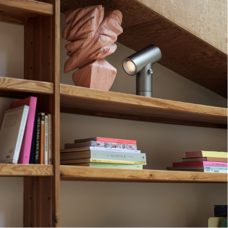 The aluminum Beam Table Lamp from Muuto on a bookshelf.