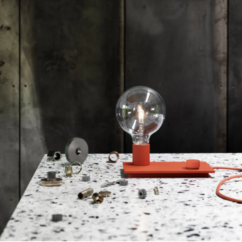 The red Control Table Lamp from Muuto in a living room.
