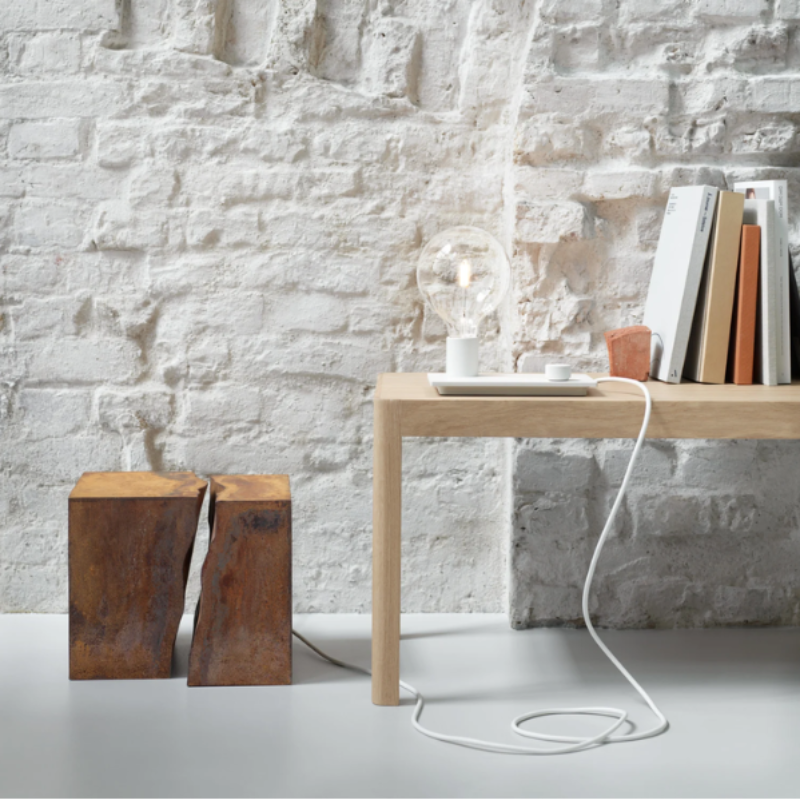 The white Control Table Lamp from Muuto in a living space.