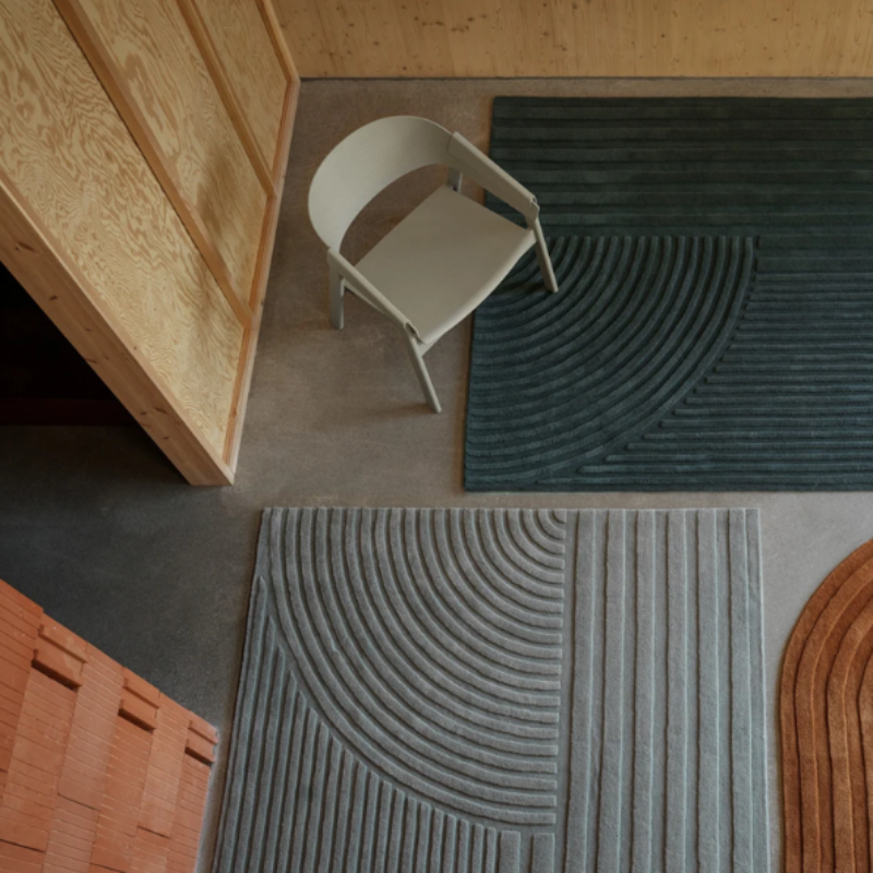 The Cover Armchair from Muuto in dark beige in a living space.