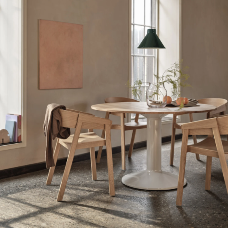 The Cover Armchair from Muuto in oak in a dining room.
