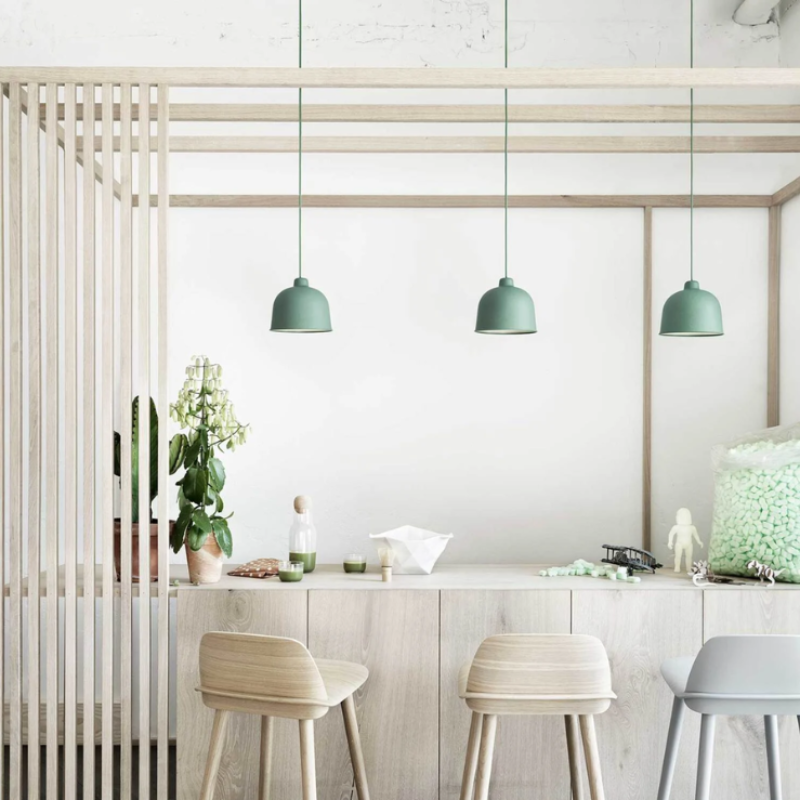 The dusty green Grain Pendant Lamp from Muuto in a living room.