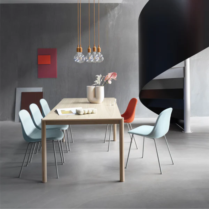 The Kink Vase by Muuto in sand within a dining room.