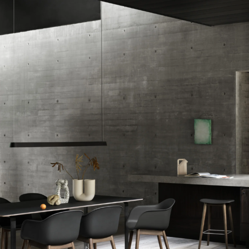 The black Linear Pendant Lamp from Muuto in a workspace.