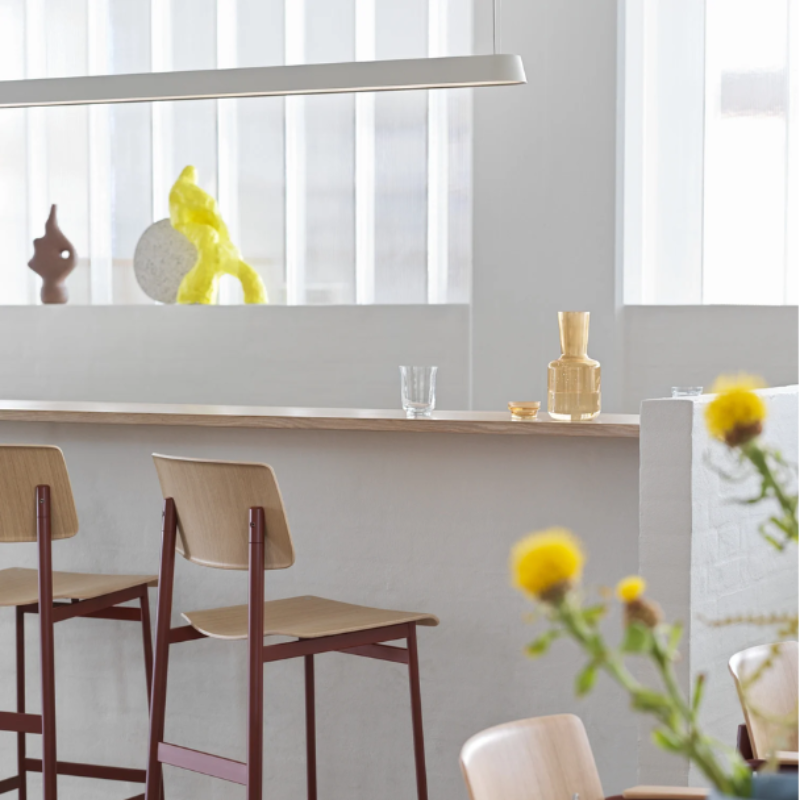 The gray Linear Pendant Lamp from Muuto above a breakfast bar.