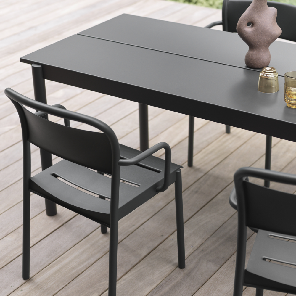 The black Linear Steel Table from Muuto in an outdoor dining area.