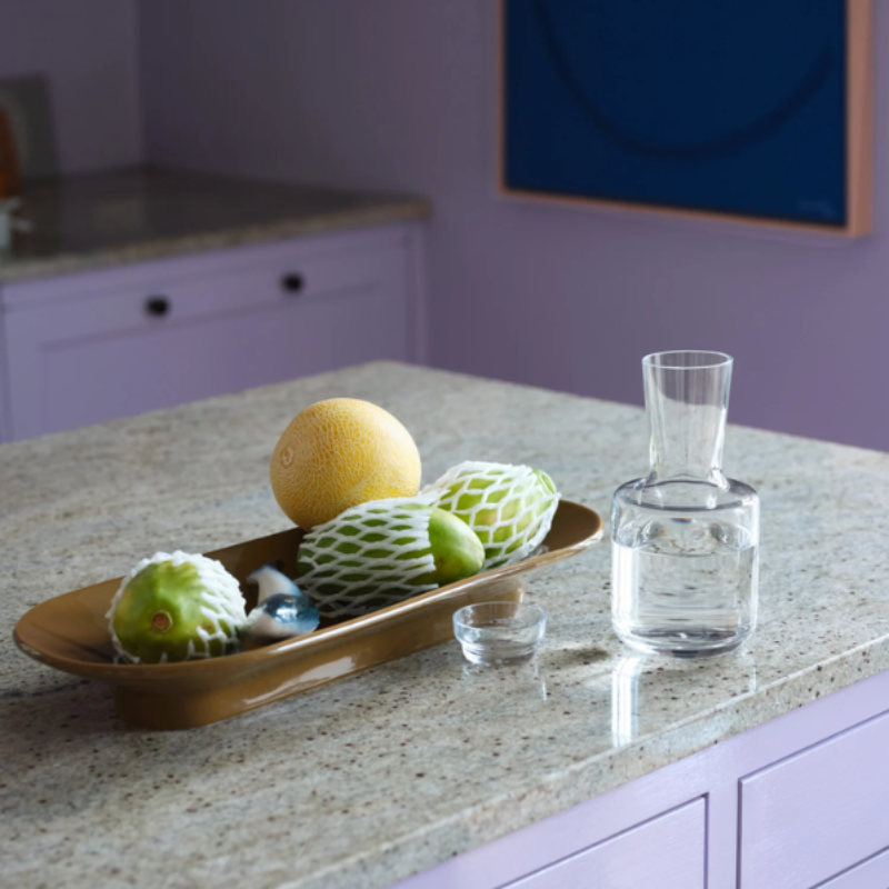 The long Mere Bowl from Muuto in brown green on a kitchen island.