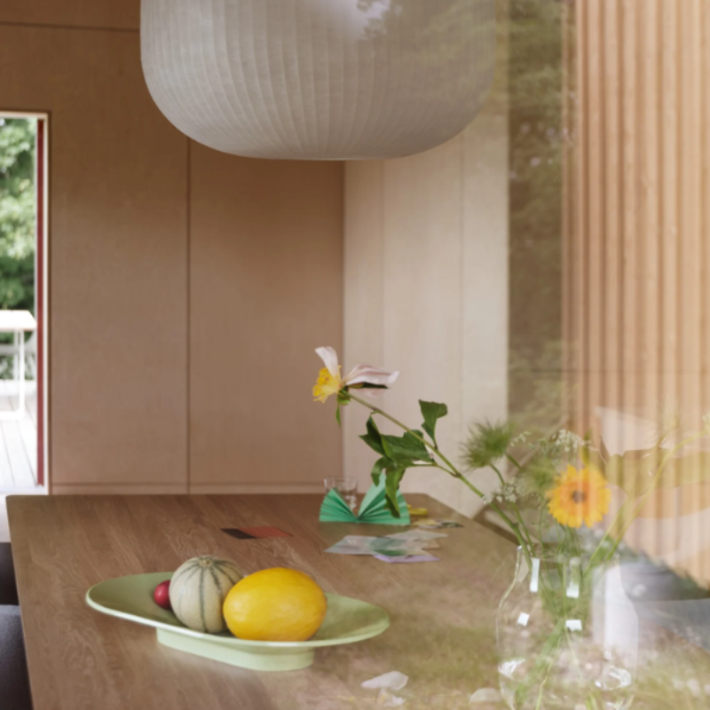 The long Mere Bowl from Muuto in light green in a dining room.