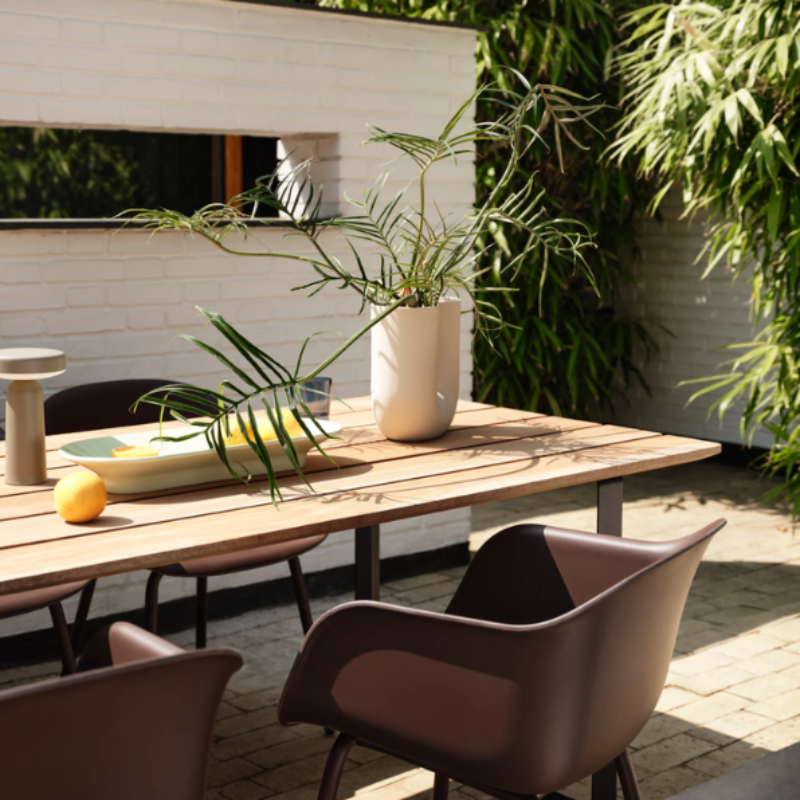 The long Mere Bowl from Muuto in light green within an outdoor dining area.