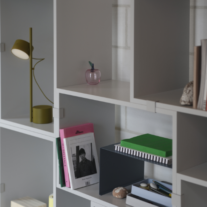 The brown green Post Table Lamp from Muuto in a lounge.