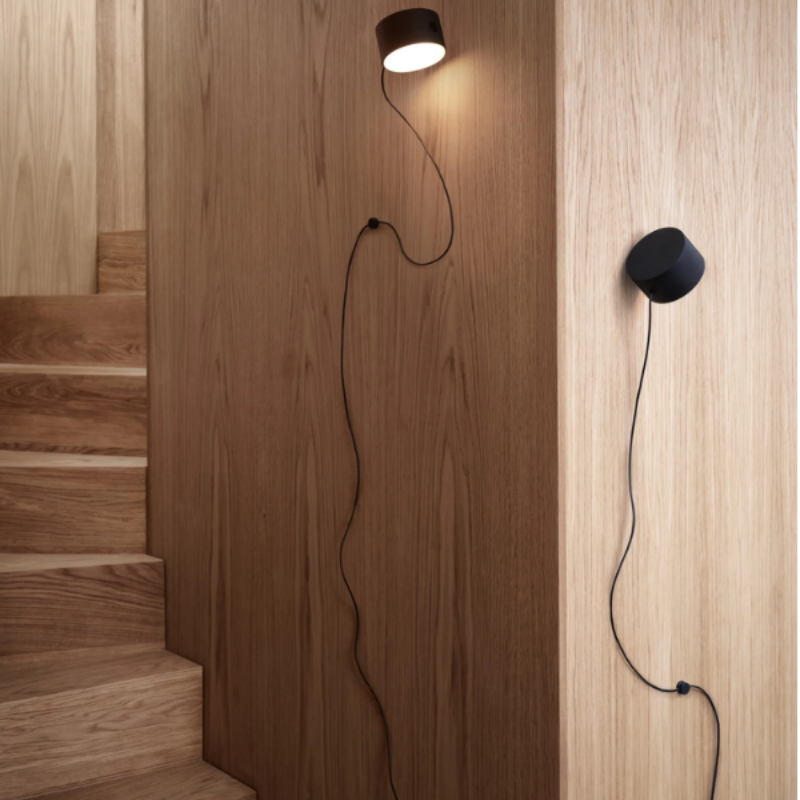 The Post Wall Lamp from Muuto in a hallway illuminating a staircase.