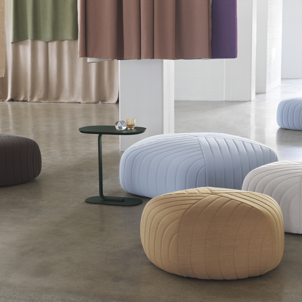 The dark green Relate Side Table from Muuto in a gathering space.