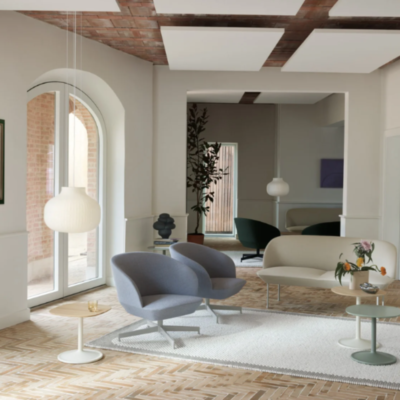 The closed Strand Pendant Lamp from Muuto, 17.7 inch size in a foyer with lounge chairs and a sofa.