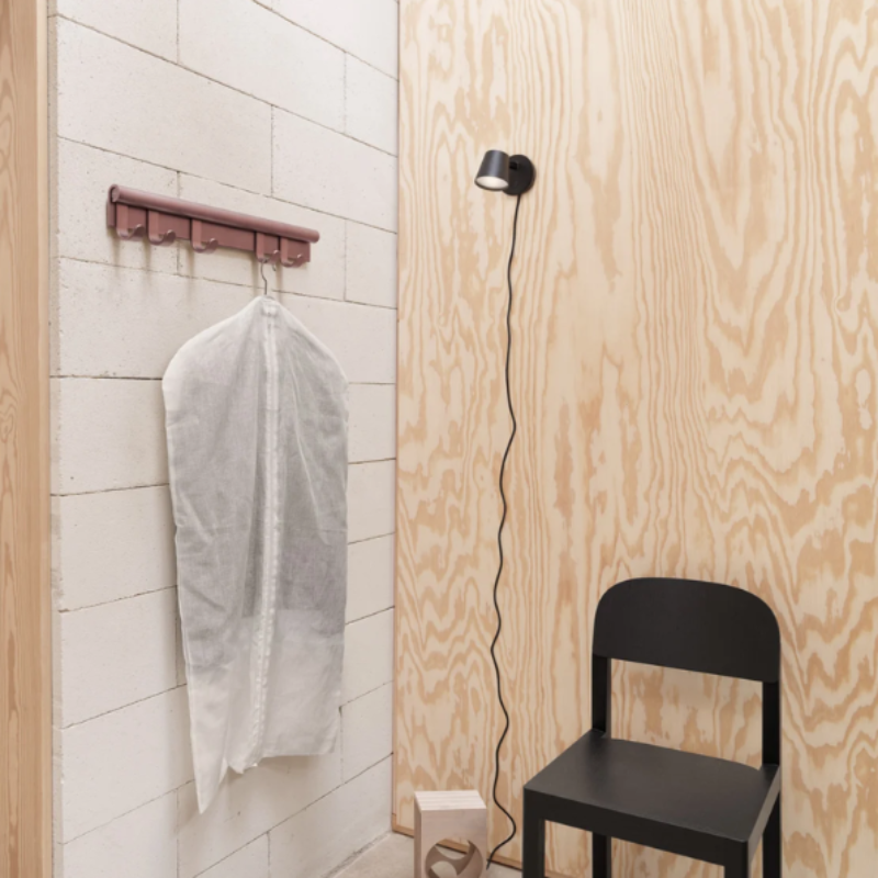 The Tip Wall Lamp from Muuto black within a primary bedroom.