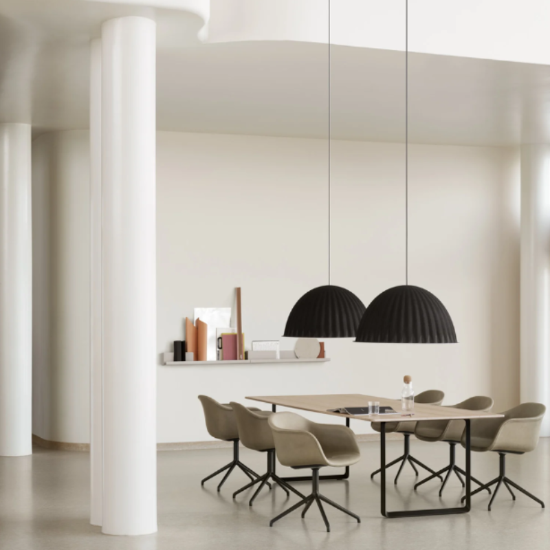 The black Under the Bell Pendant Lamp from Muuto in an office.