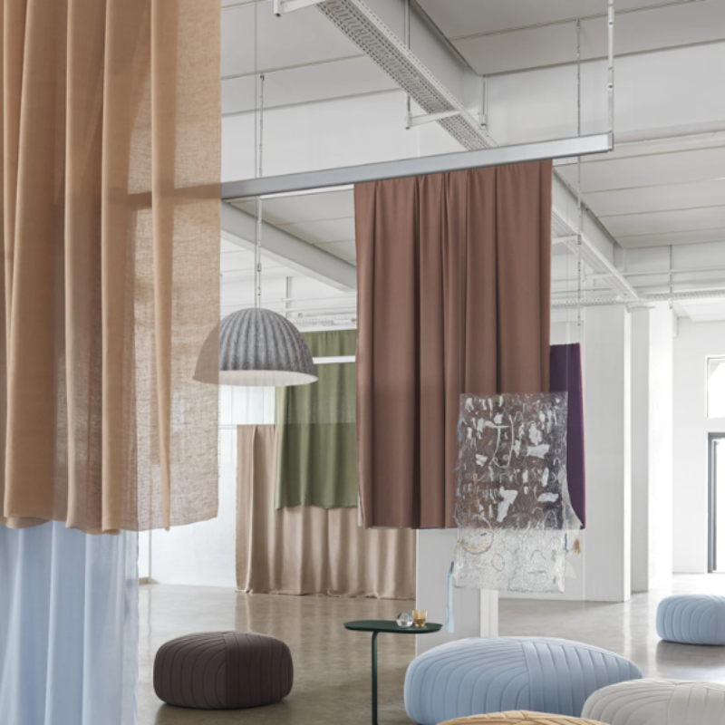 The gray Under the Bell Pendant Lamp from Muuto in a lounge.