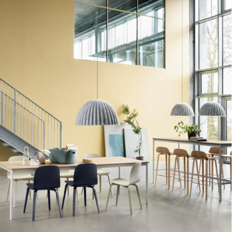 The gray Under the Bell Pendant Lamp from Muuto in an open space home.